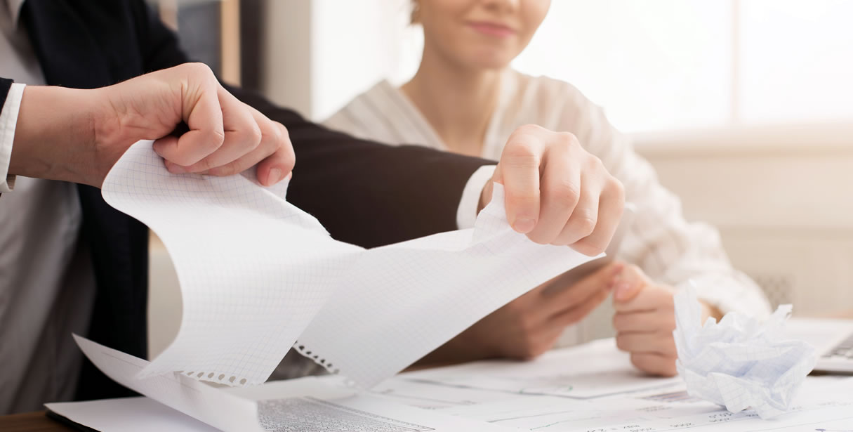 Man rips paper as woman smiles